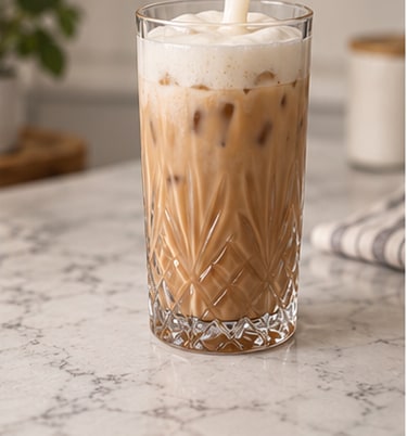Cold foam poured on top of an iced chai latte