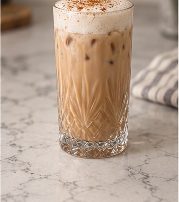 A finished iced chai latte with foam